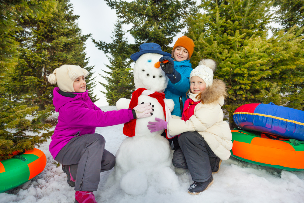 Kids building a snowman - Budget-friendly winter outdoor activities - Kids Outside Adventures