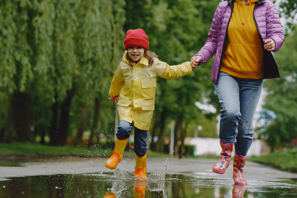 Parent and child jumping in rain puddles - Rainy Day Activities for Families - Kids Outside Adventures