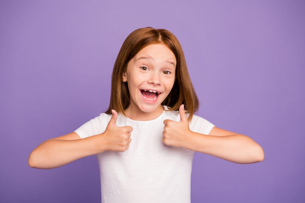 Very happy girl holding two thumbs up - Kids Outside Adventures